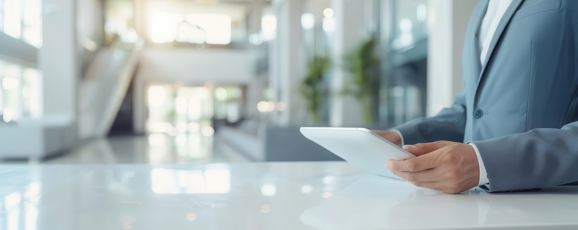 Professional reviewing a digital visitor management tablet at a modern reception desk in a secure corporate lobby, representing AI-native security and compliance solutions for government contractors and public agencies.